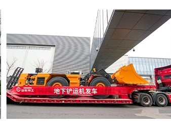 Underground mining loader departing on a flatbed trailer